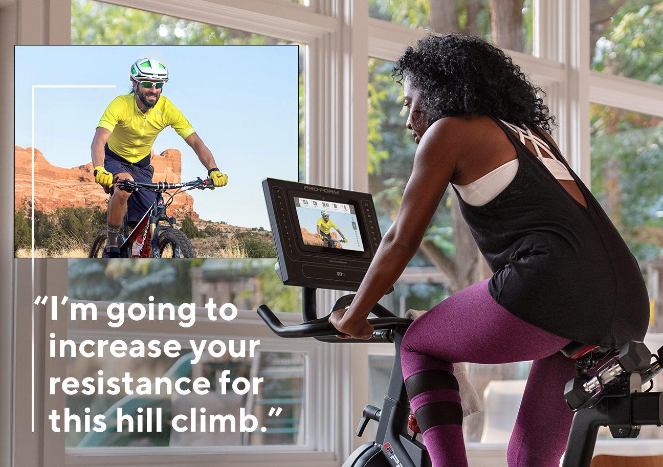 Young african american woman cycling competitively with an online trainer with a caption